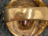 a close up of a gold ring on a black surface