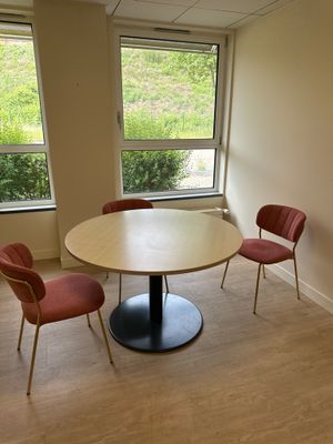 trois chaises disposées autour d'une table ronde dans une pièce