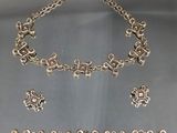 un gros plan d'un collier et d'un bracelet en argent posés sur une table