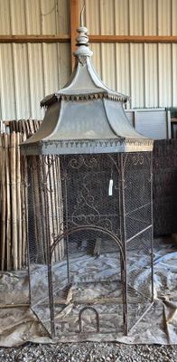 une cage à oiseaux sur laquelle est posé un oiseau