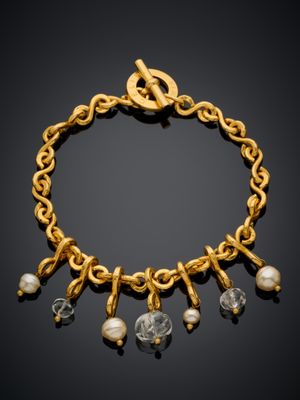 un bracelet en or orné de perles et de breloques sur fond noir