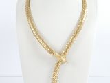 Le collier est en métal doré et comporte un nœud.
