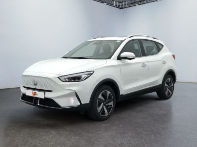 un SUV blanc garé dans une grande pièce au sol noir