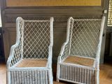 une paire de chaises en osier blanc posées sur un parquet dans un salon