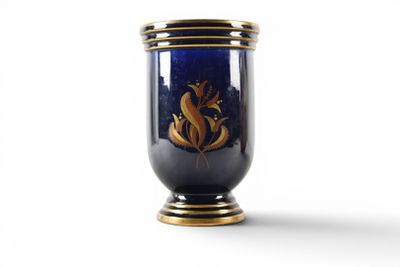 a blue vase with a gold decoration on it