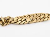 gros plan d'un bracelet en or sur fond blanc