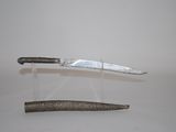 a knife on a stand next to a knife on a table