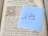 un livre sur lequel est posée une note bleue et un bout de papier sur lequel figure le mot, à droite de celui-ci