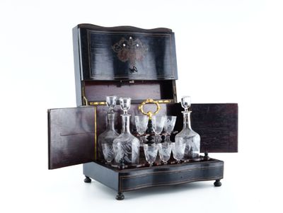 bottles and glasses in a wooden case on a white surface
