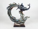 sculpture of a peacock on a branch with a flower in its beak