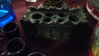 un vase vert et un verre bleu posés sur une table