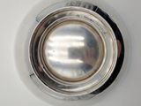 a close up of a silver plate on a white surface