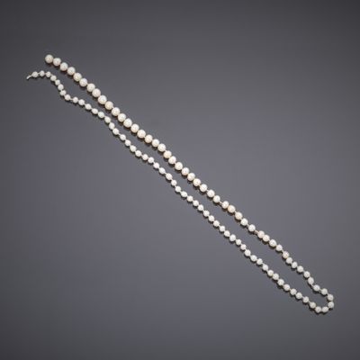 a white pearl necklace with a gold clasp on a gray background