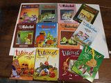 de nombreux livres pour enfants posés sur une table, à côté d'un ordinateur portable