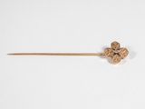 un gros plan d'une broche en or ornée d'une fleur