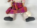 a doll that is sitting on a white surface
