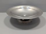 a silver plate on a silver stand on a table