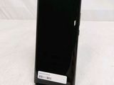 the back of a black cell phone sitting on top of a table