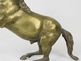 bronze statue of a horse standing on its hind legs on a white surface