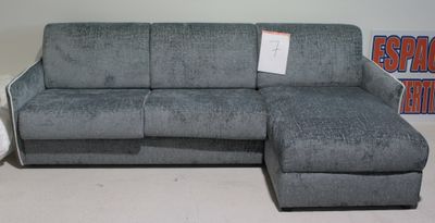 un canapé gris avec une méridienne, placé devant un panneau
