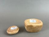 two small wooden bowls sitting on top of a gray surface