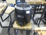 a black pot sitting on a wooden table in a room