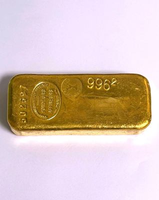 gros plan d'un lingot d'or sur une surface blanche