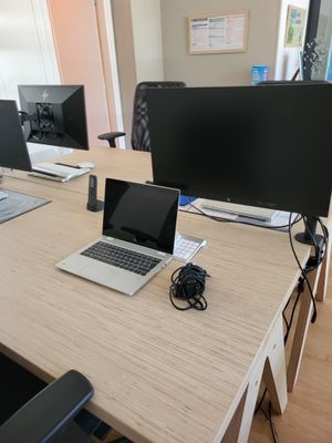 un bureau sur lequel sont posés deux ordinateurs et un ordinateur portable