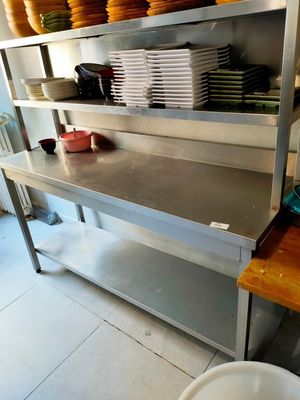 de nombreuses assiettes et bols posés sur une étagère en métal dans la cuisine
