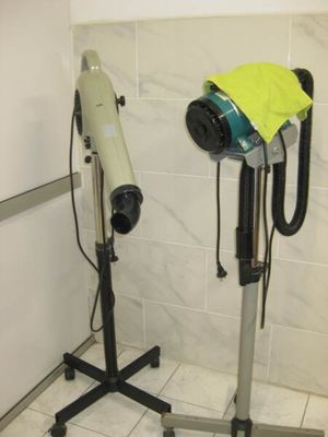 deux sèche-cheveux posés sur un support dans une salle de bains