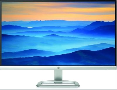 the computer monitor is on a stand with a mountain view in the background