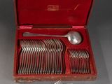 un coffret rouge contenant de l'argenterie sur une table