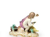 a figurine of a woman sitting on a rock