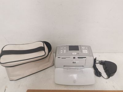un sac et une imprimante posés par terre à côté d'un sac