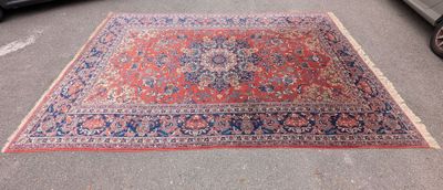 a rug on the ground next to a car on the street