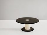 une table basse noire et blanche avec un plateau rond en verre