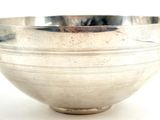 a silver bowl on a white surface with a white background