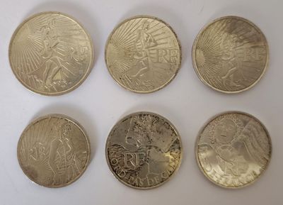 six types de pièces différents sont présentés sur une surface blanche