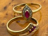 pair of ruby and diamond rings on a wooden surface