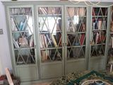 a bookcase with many books in it in a room
