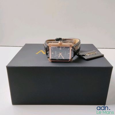 une photo d'une montre posée sur une boîte, elle-même posée sur une table