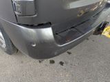 a black truck with a yellow tag on it ' s bumper