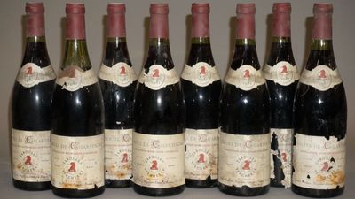 six bouteilles de vin sont alignées sur une table