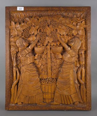 une plaque en bois sculpté représentant un groupe de femmes portant des paniers de fruits