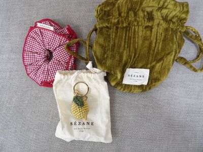 deux sacs avec un porte-clés en forme d'ananas, un sac avec un porte-clés en forme d'ananas et un sac avec un porte-clés en forme d'ananas
