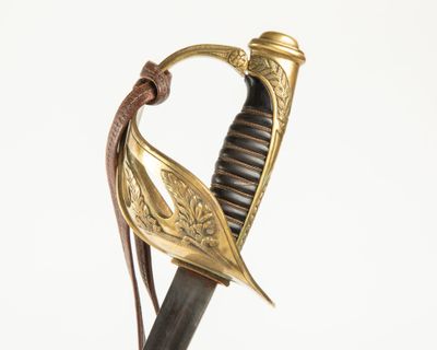 une vieille épée avec une poignée en or et une feuille gravée sur la lame
