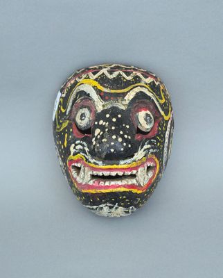 une image représentant un masque en bois sur lequel est peint un visage