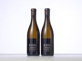 two bottles of white wine sitting on top of a table