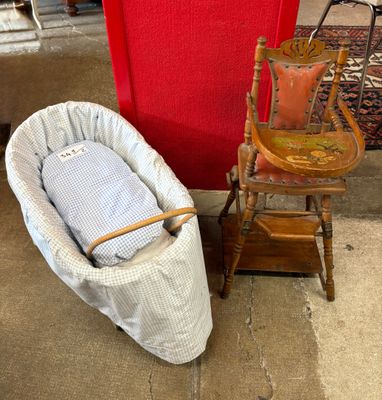 un bébé dans un panier posé à côté d'un fauteuil à bascule