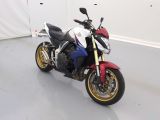 une moto rouge, blanche et bleue garée dans une pièce